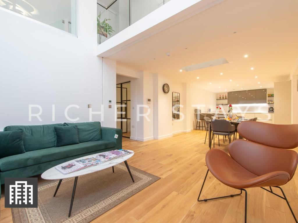 伦敦Exquisite 3BR Duplex Period Conversion, Air-con & Amenities的客厅配有绿色沙发和桌子
