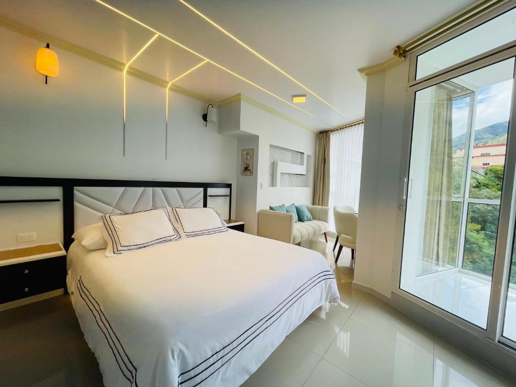 巴尼奥斯Hostal Balcon del Cielo的卧室设有白色的床和大窗户