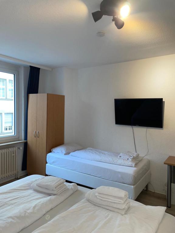 斯图加特TRUST Hotel & Apartment的配有平面电视的客房内的两张床