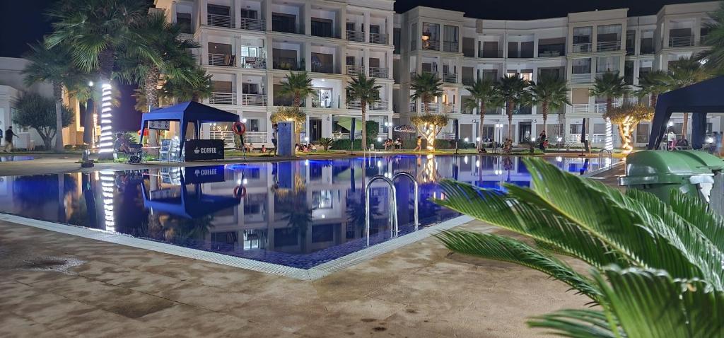 布兹尼盖COSTA BEACH Lux Family Apartment with Pools的一座游泳池,在晚上在建筑物前