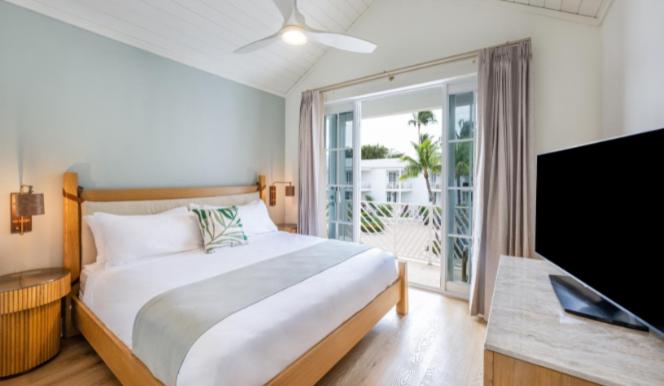 伊斯拉莫拉达Islander Bayside Villas & Boatslips的一间卧室配有一张床和一台平面电视