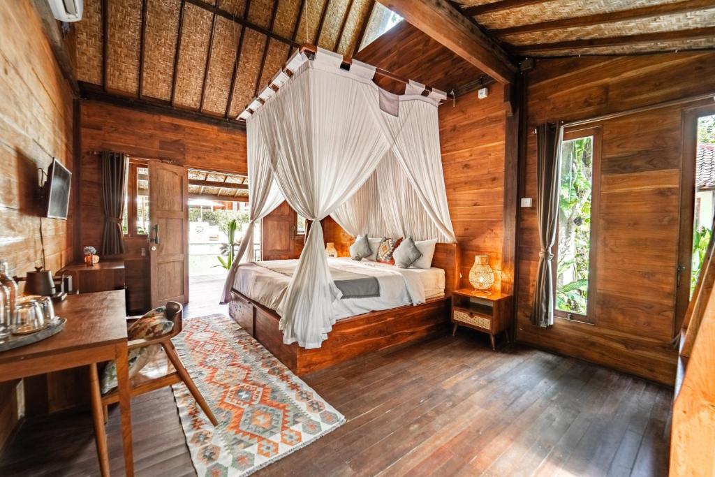 乌鲁瓦图Kayu Mama Resort and Spa的一间卧室配有一张带蚊帐的床