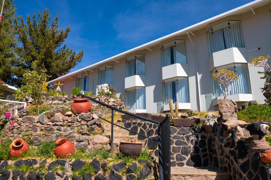 普诺Lake Titicaca Hotel的一座石墙建筑,一些植物