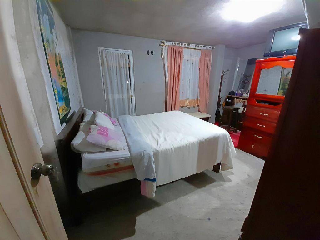 奥塔瓦洛ENCALADA的卧室配有白色的床和梳妆台。