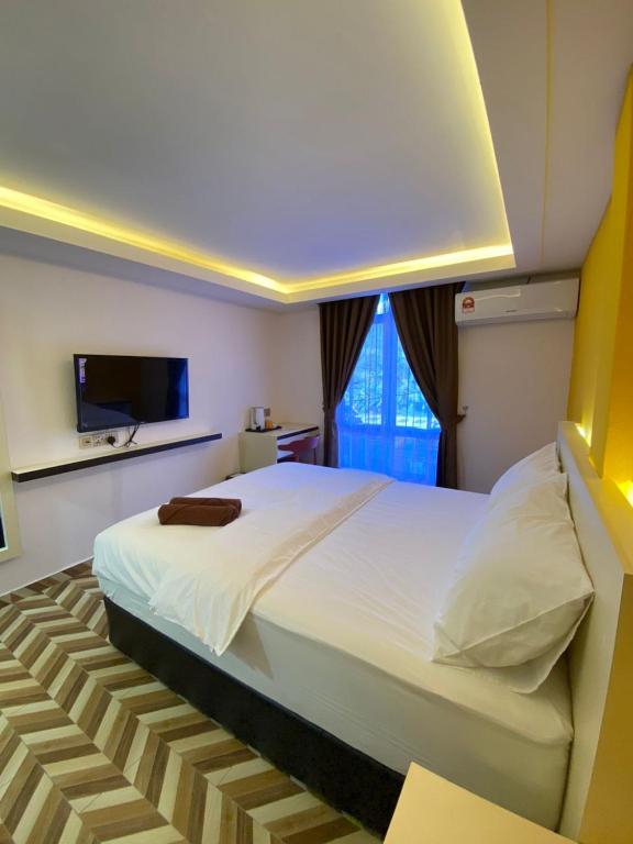 MacangD SEGA HOTEL的卧室配有一张白色大床和电视。