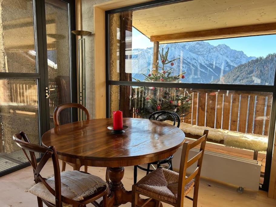 VnaBijoux in the Swiss mountains的窗户客房内的一张木桌和椅子