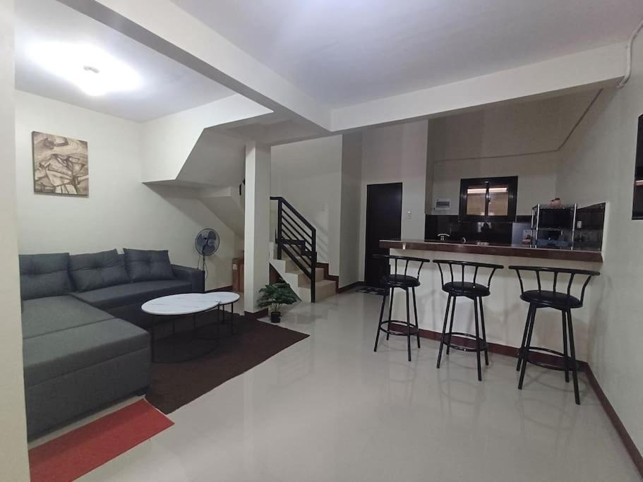 利帕Affordable 2 BR Transient House in Lipa City Batangas的带沙发和桌子的客厅以及厨房。