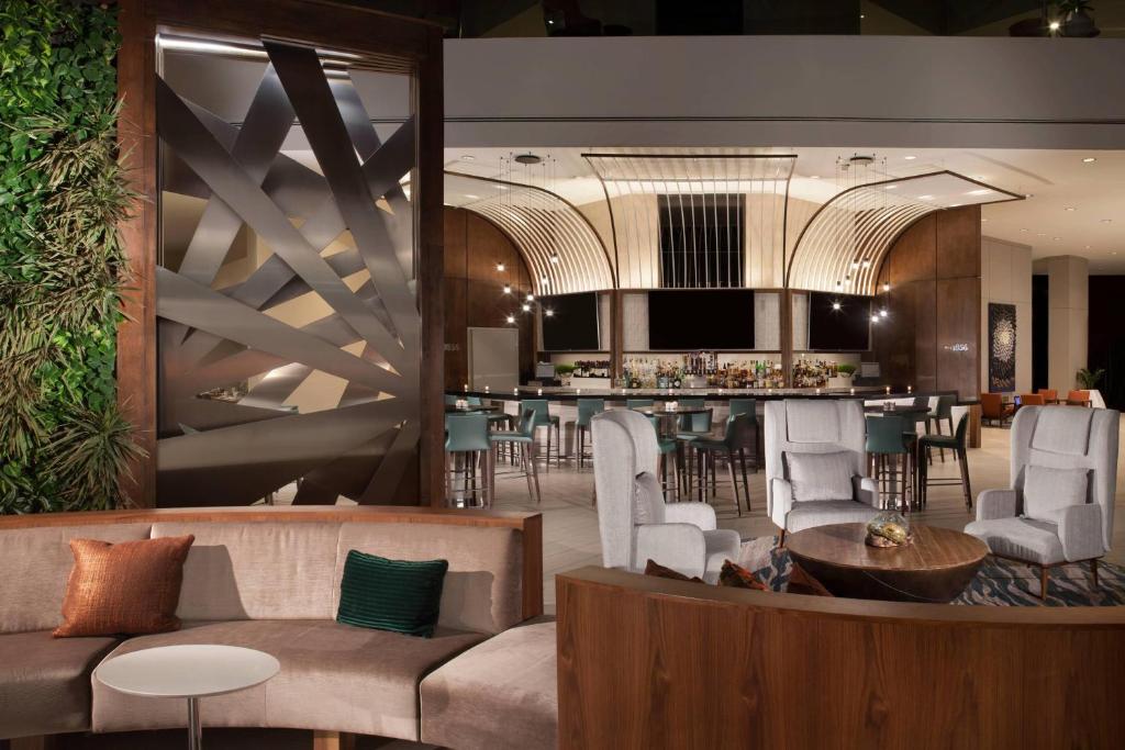 达拉斯威斯汀达拉斯公园中心酒店的大堂设有带椅子和桌子的酒吧