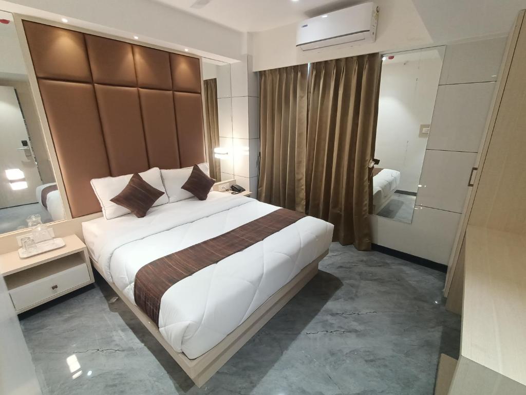塞恩Hotel Pearl Residency的酒店客房设有一张大床和一间浴室。