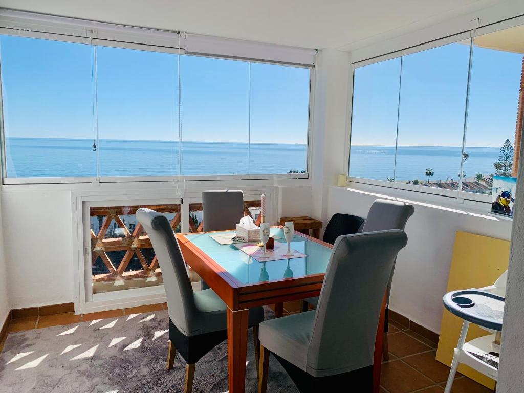 马尼尔瓦Seaview Penthouse Magnificó Ático Duplex con vistas al mar的一间配备有桌椅的海景用餐室