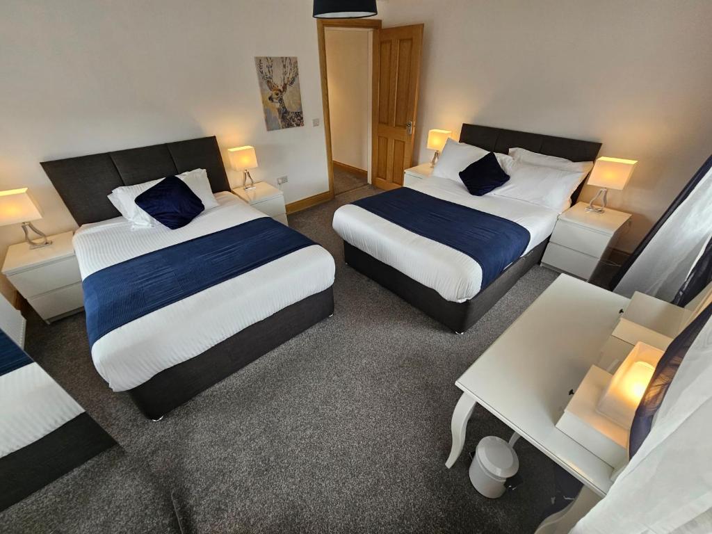 卡索曼Holiday in The Heart of Kerry的酒店客房设有两张床和一张桌子。