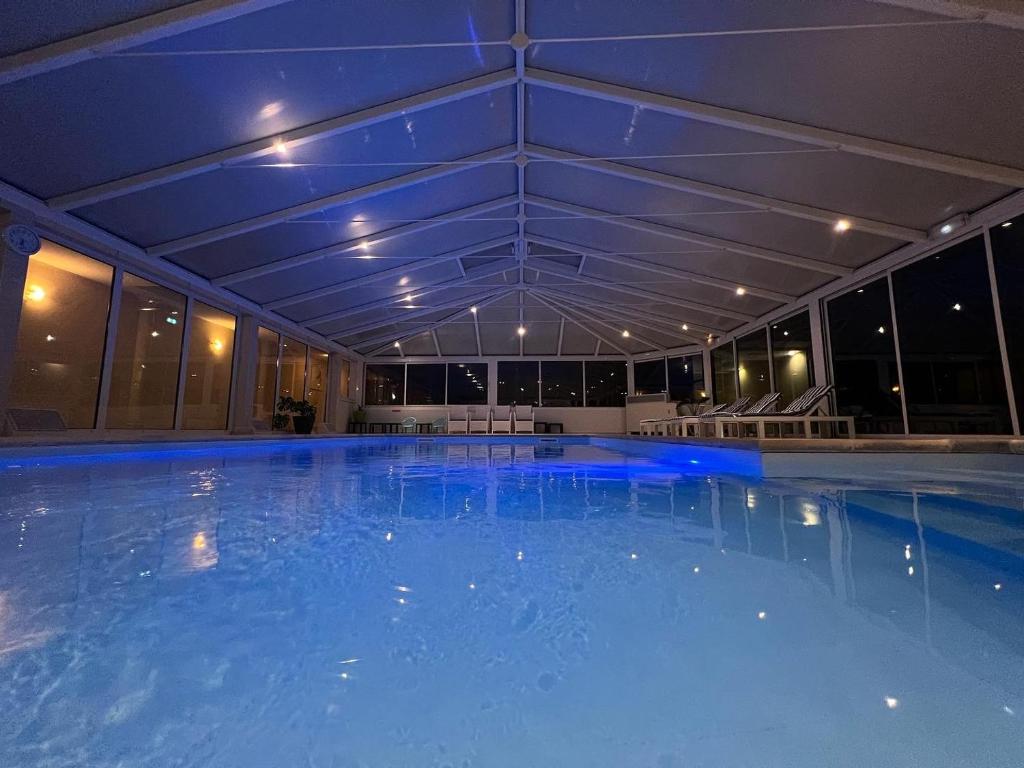 贝热尔莱韦蒂Logis Hostellerie Du Mont Aimé的一座拥有蓝色灯光的大型游泳池