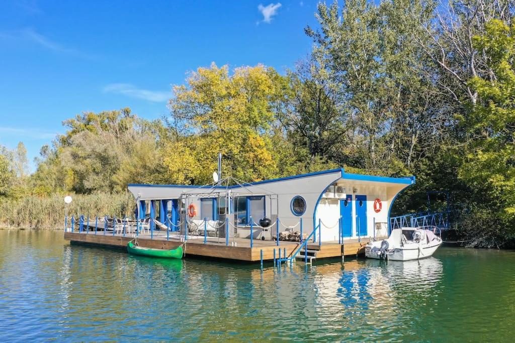 布拉迪斯拉发Očarujúci Houseboat na Dunaji的船屋停靠在水面上