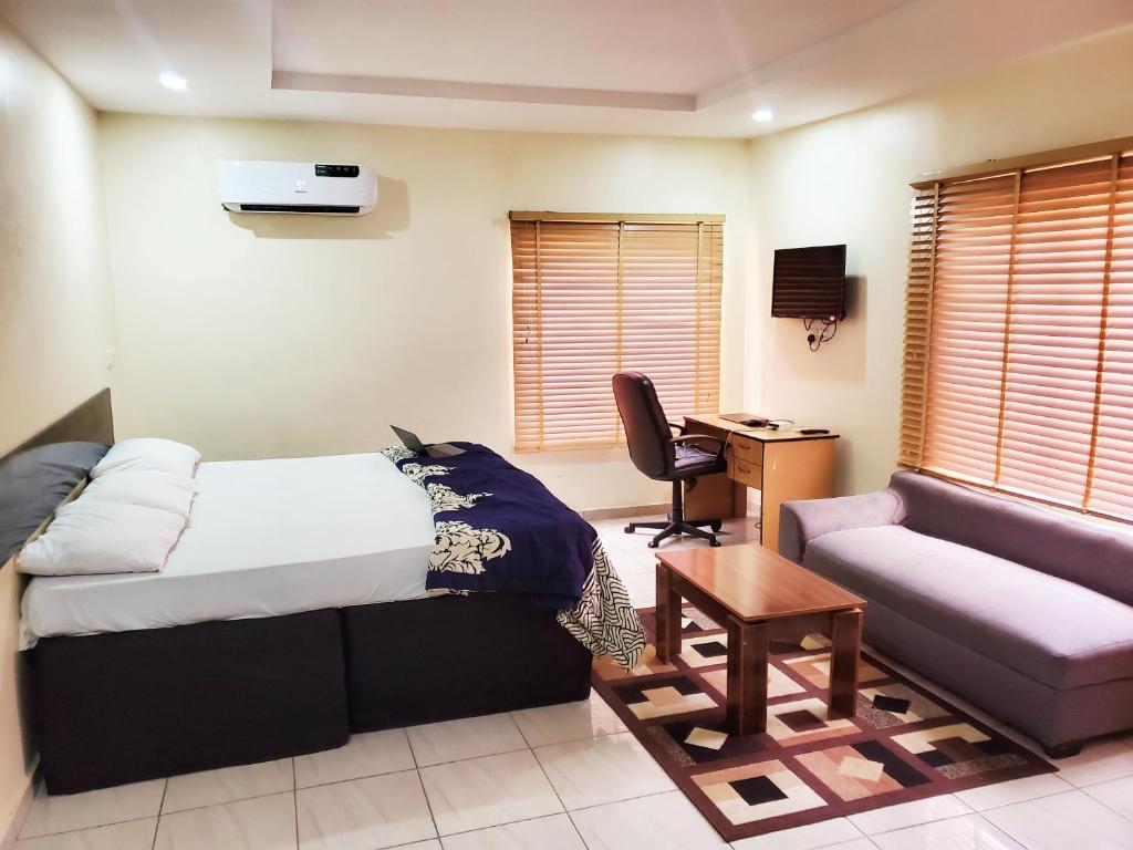 AsoCentral District Apartment (Abuja)的客房设有床、沙发和书桌。