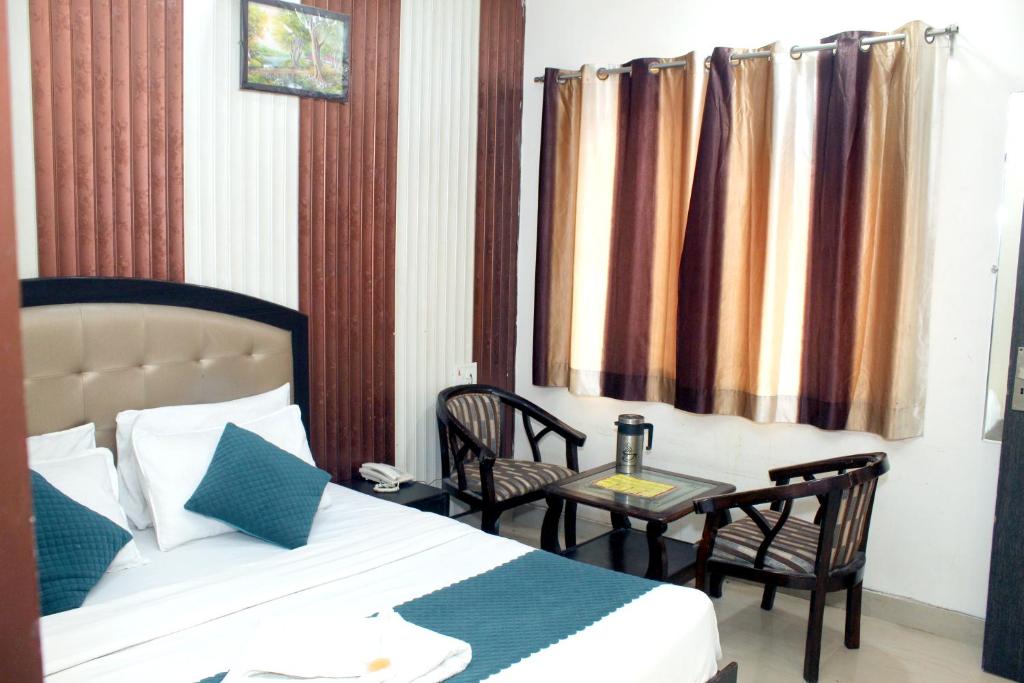 哈里瓦Hotel Anand的卧室配有一张床和一张桌子及椅子