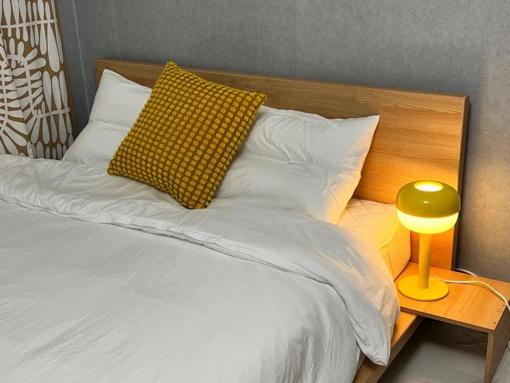 首尔Masil的一张带黄色枕头和黄色灯的床