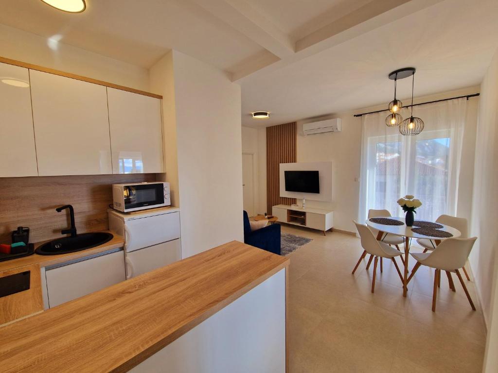 格拉达茨Apartment Ana - Gradac的厨房以及带桌椅的起居室。