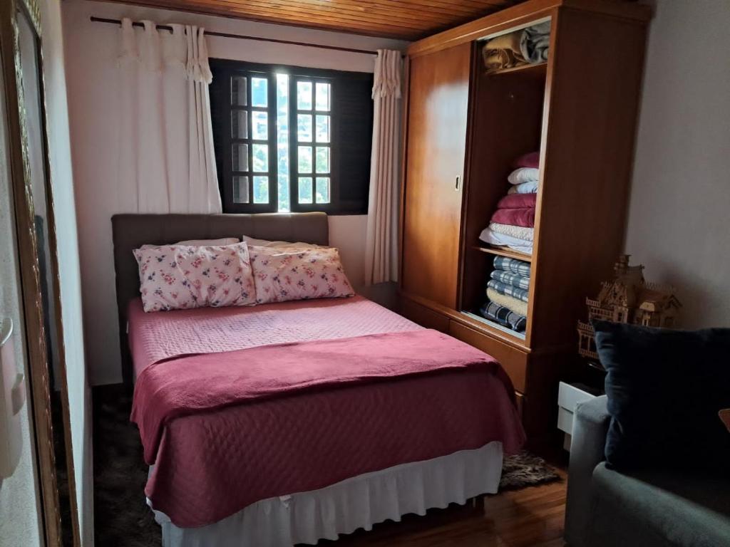 坎波斯杜若尔当Casa de Boneca的一间卧室配有一张带粉色床单的床和一扇窗户。