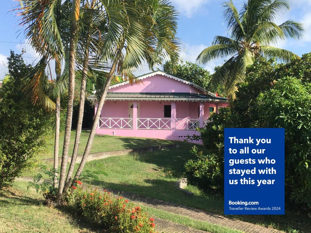 ChoiseulThe Pink House的粉红色的房子,上面有标志,上面写着感谢所有入住客人