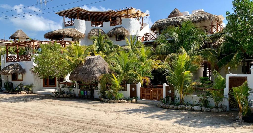 奥尔沃克斯岛El Corazón Boutique Hotel - Adults Only with Beach Club's pass included的前面有一棵棕榈树的房子