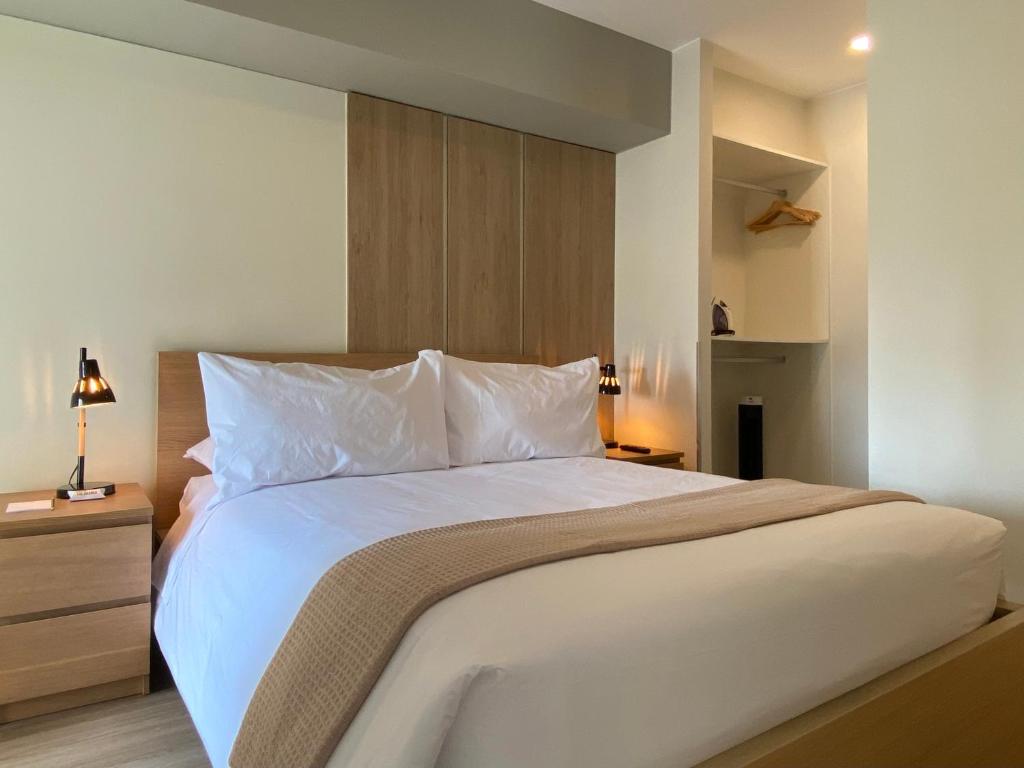 利马La Mar Miraflores by Wynwood House的卧室配有一张带白色床单和枕头的大床。