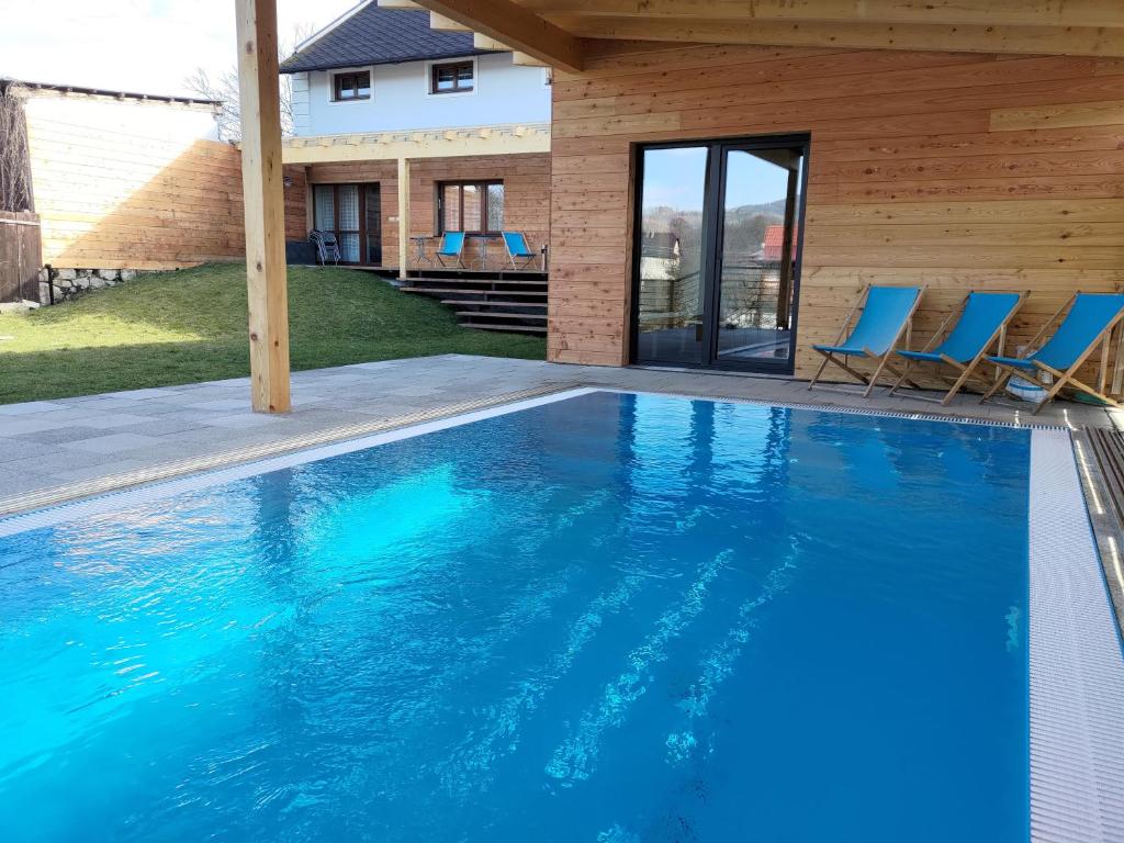 大洛西尼思维卡克拉森斯基酒店的一个带蓝色椅子的游泳池