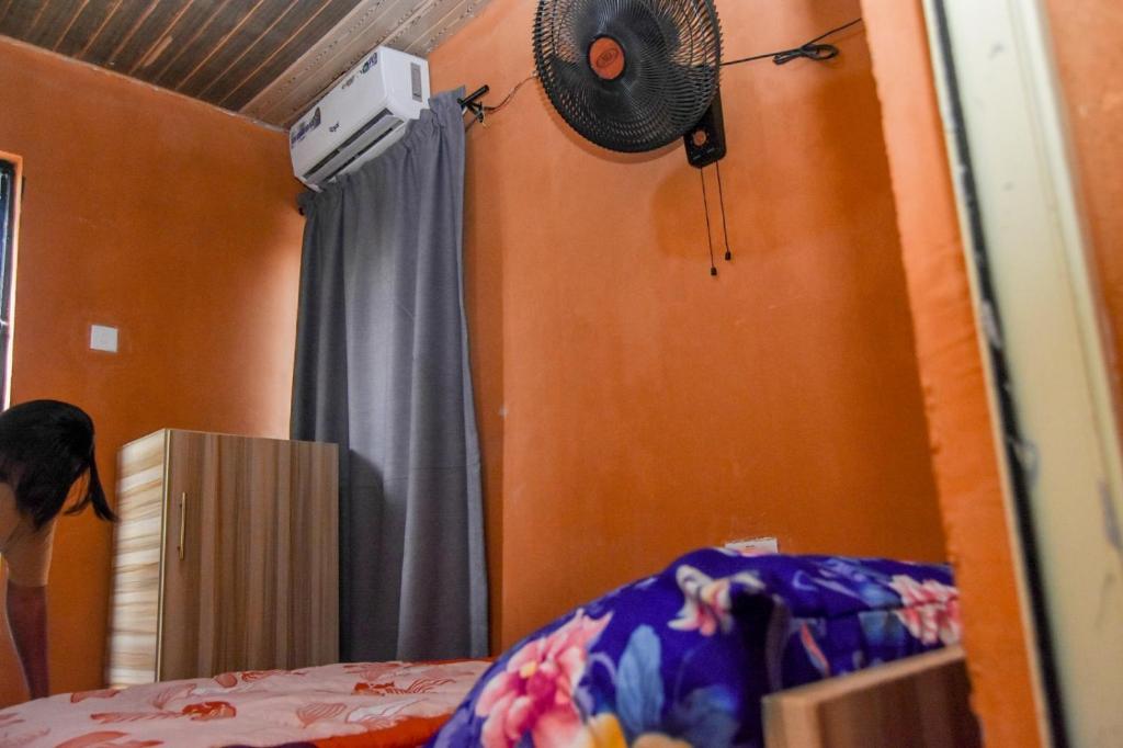 IkoroduMore Point Lounge的卧室配有一张床,墙上配有风扇