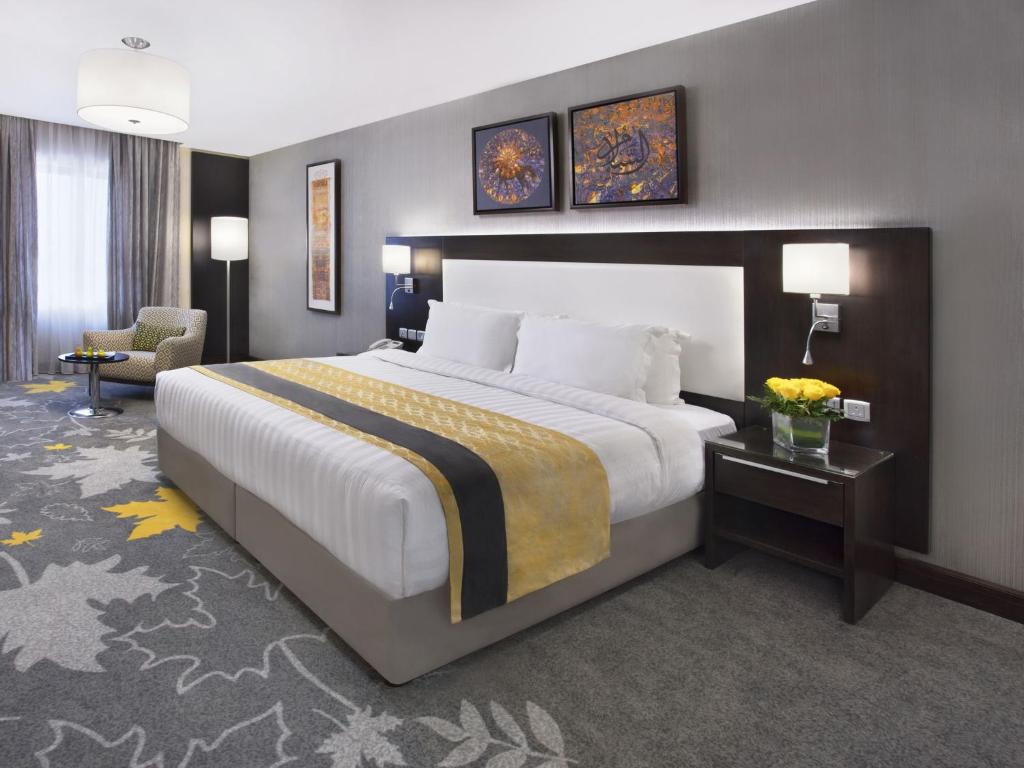 吉达Warwick Hotel Jeddah的酒店客房带一张大床和一把椅子