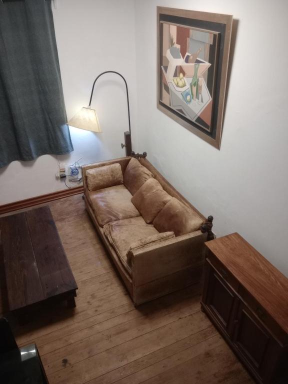 蒙得维的亚Casa Bruniel的客厅配有一张棕色沙发,配有一张桌子