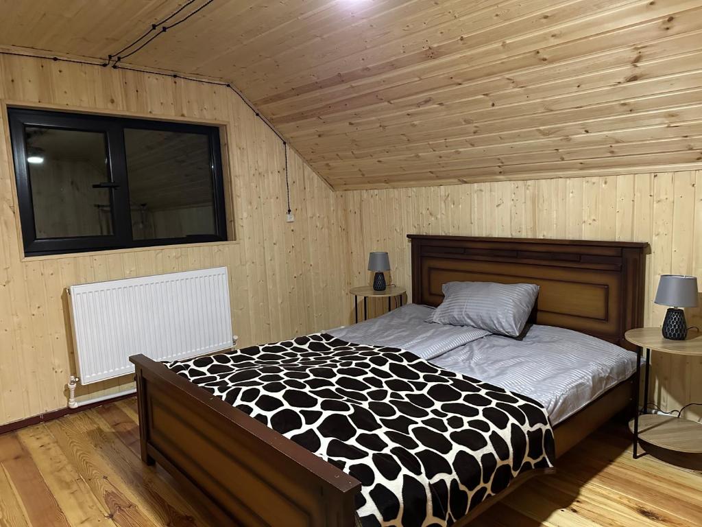KiketʼiCozy Wooden House in Kiket'i კიკეთი的一间卧室配有一张带黑白色棉被的床