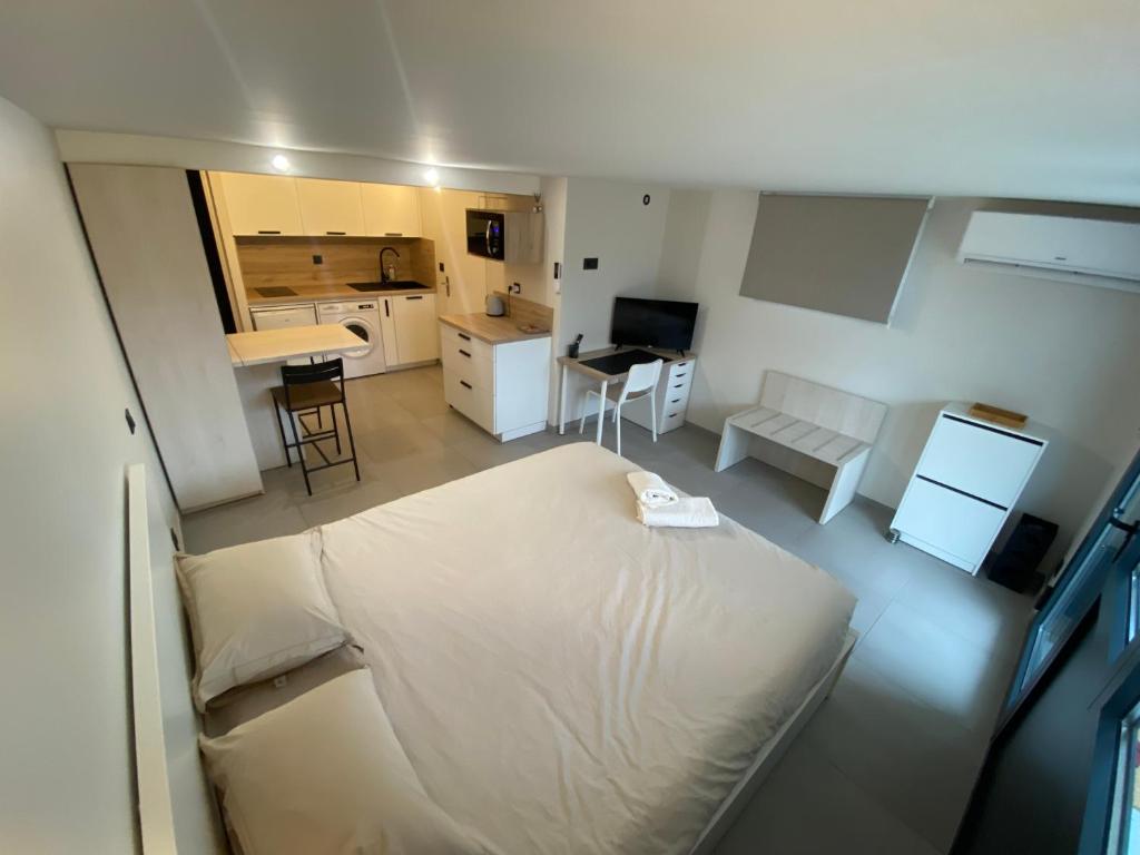 GriègesStudio chez l'habitant avec piscine commune的一间带白色大床的卧室和一间厨房