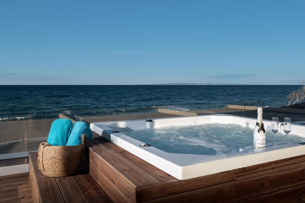 阿凯松Kavo Seaside Luxury Apartment的背景为一个按摩浴缸,享有海景
