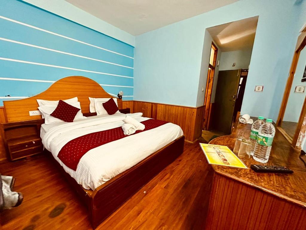 马拉里The Kanchan Hotel & Restaurant Manali的一间卧室配有一张大床和木制床头板