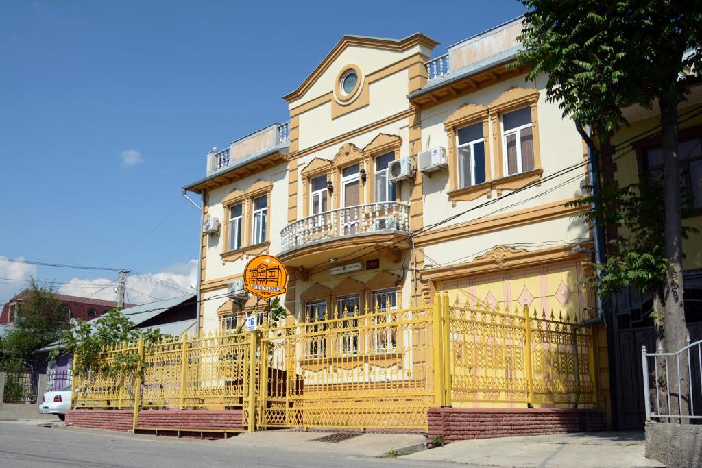 杜尚别Yellow Hostel Dushanbe的黄色的建筑,前面有黄色的栅栏