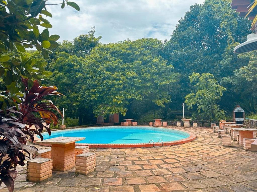 伦索伊斯Encanto do Parque Hospedagem的一座树木繁茂的庭院内的游泳池