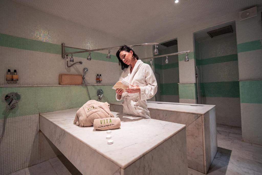 卡萨布兰卡New Hotel Piscine Wellness & Spa的站在带水槽的浴室中的女人