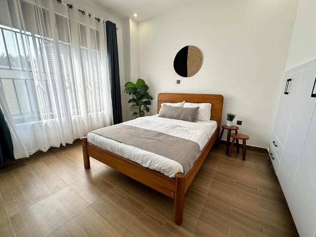 基加利Coalescence Hotel Rwanda的卧室配有带白色墙壁和窗户的床