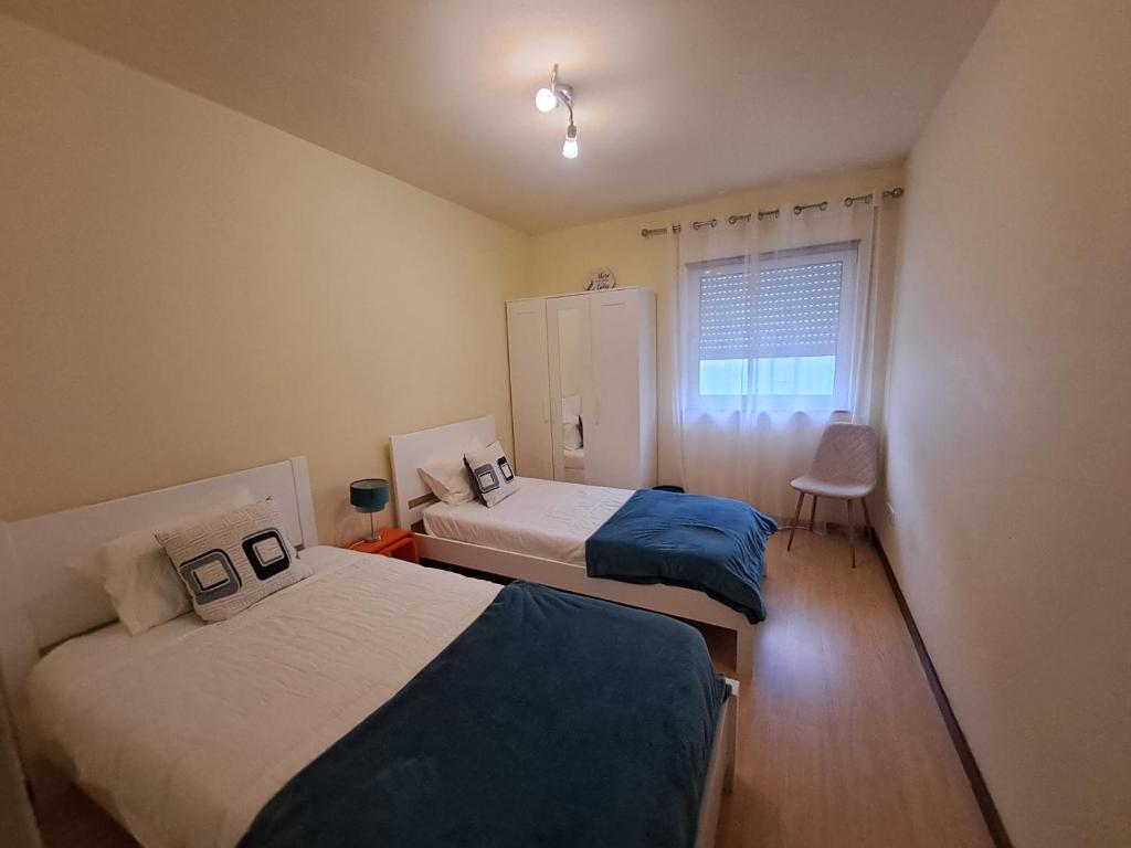 蓬塔德尔加达Apartment Sweet Home的一间卧室设有两张床和窗户。