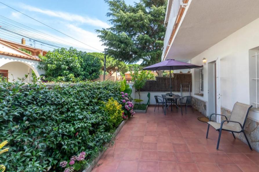 萨卡罗Apartamento en S agaró zona tranquila的庭院设有椅子和遮阳伞以及树 ⁇ 