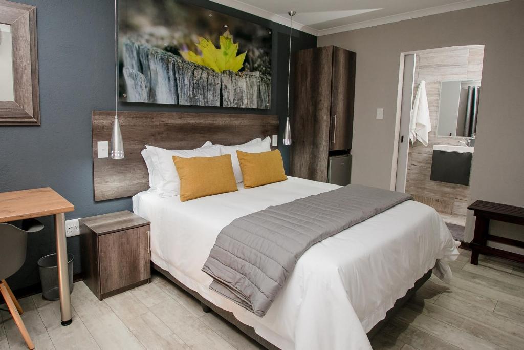 内尔斯普雷特Vinique Guesthouse的卧室配有一张带黄色枕头的大型白色床。