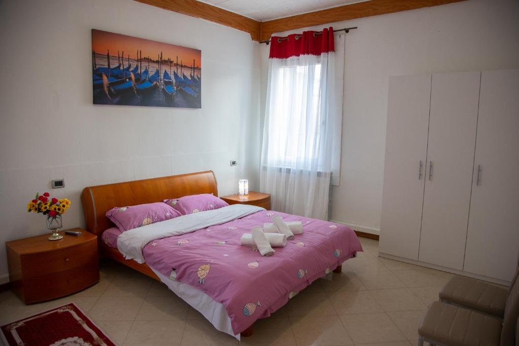 马格拉BB CA VENEZIA的一间卧室配有一张带粉红色棉被的床