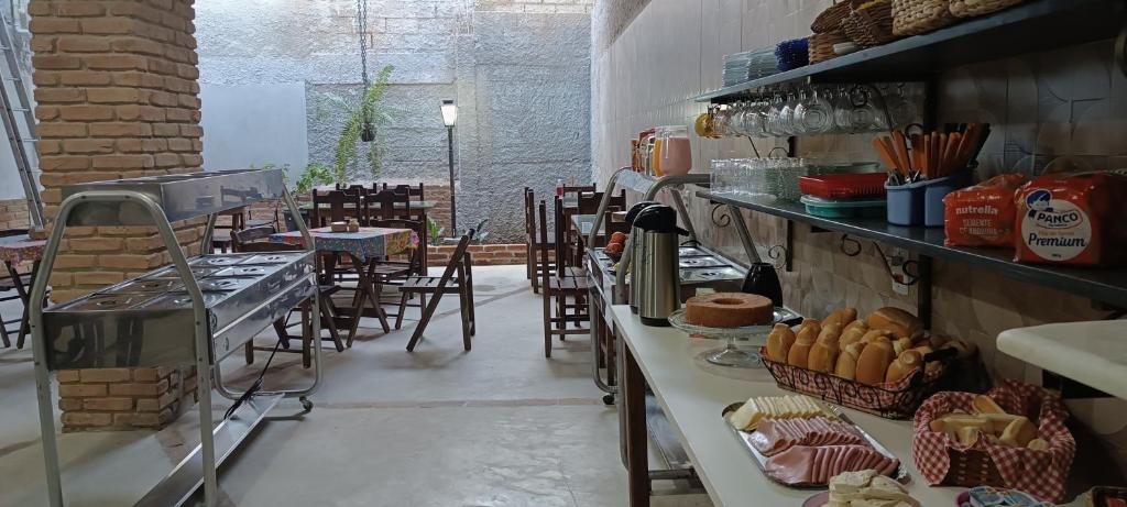 阿帕雷西达Pousada Ribeirinha的面包店配有桌椅和蛋糕柜台