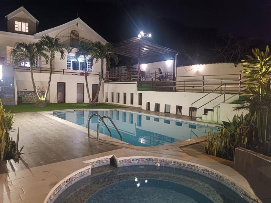 昆卡Casa de campo Country house in Yunguilla, Cuenca, Ecuador的夜间在房子前面的游泳池