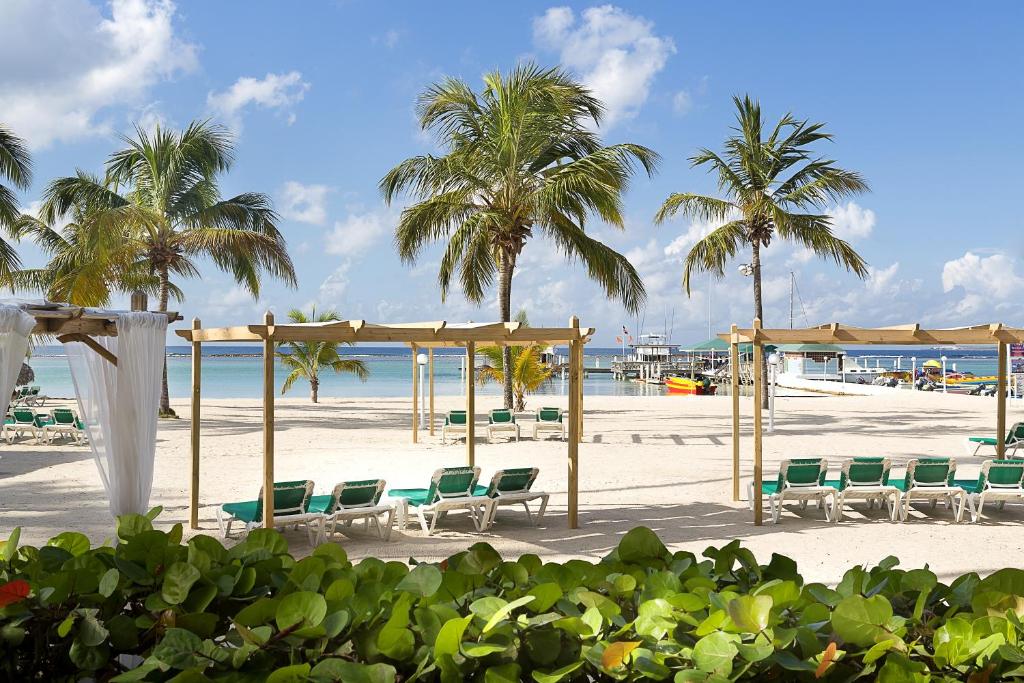 博卡奇卡瓦拉波希卡全包度假村的海滩上设有椅子和遮阳伞,棕榈树