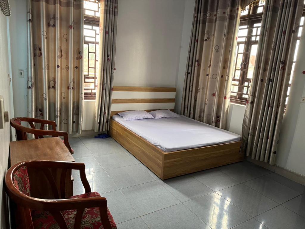 荣福克Minh Tâm Hotel ( Nhà Nghỉ Minh Tâm )的一间小卧室,配有床和2个窗户