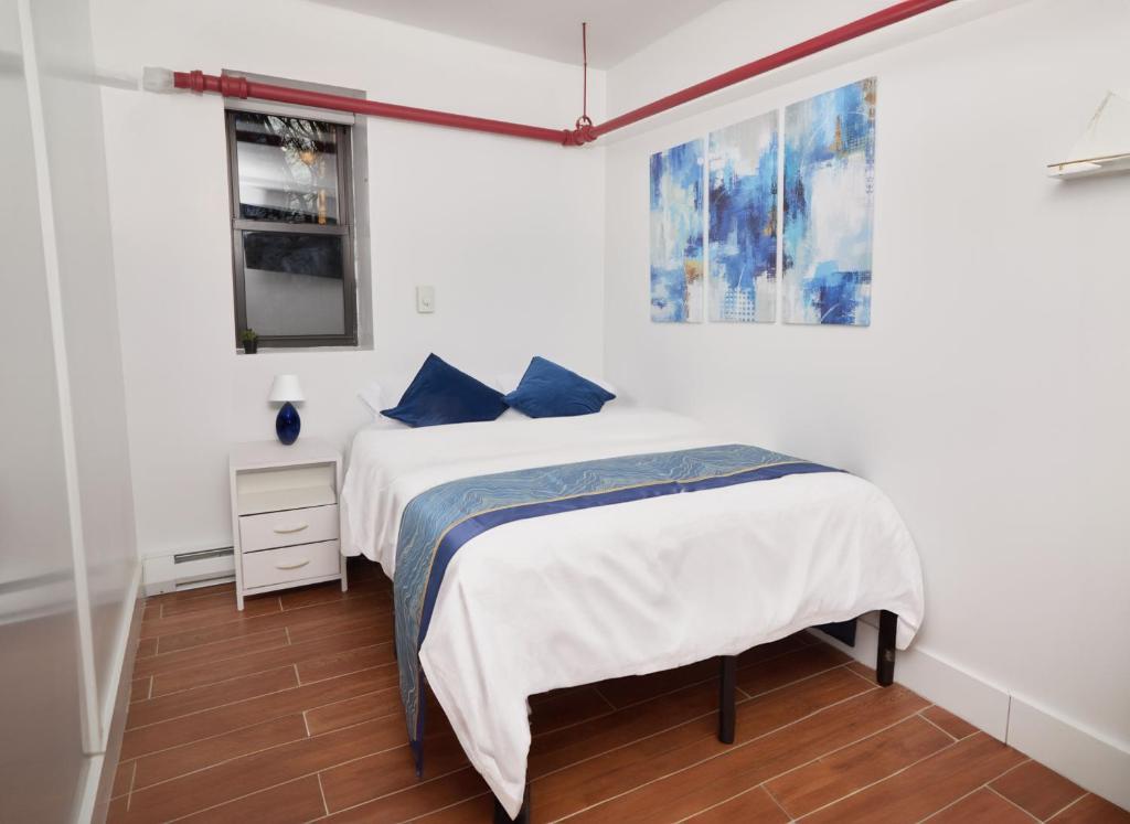 纽约Comfy Guest House in Hell's Kitchen的一间卧室配有一张带蓝色枕头的床