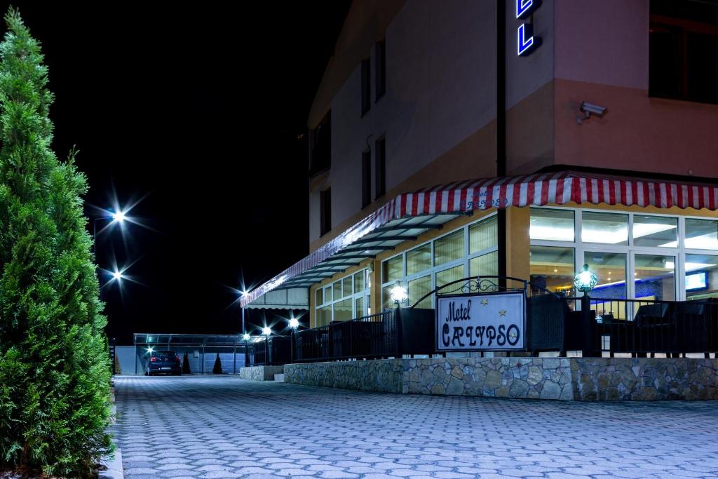 特拉夫尼克Motel Calypso Travnik的一座建筑,在晚上前有标志