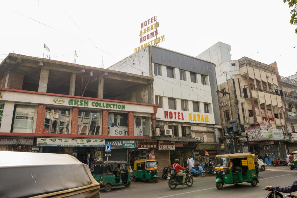 艾哈迈达巴德Hotel Aaram Kalupur的一条繁忙的城市街道,街道上有很多汽车、摩托车和建筑