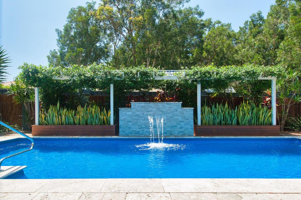 萨拉曼德湾Luxury Stay with Private Heated Pool in Salamander Bay的庭院中一个带喷泉的游泳池