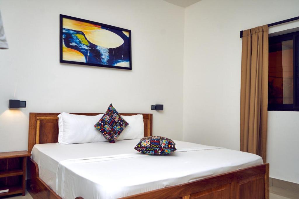 洛美AZURIA HOTEL的卧室配有白色的床和两个枕头